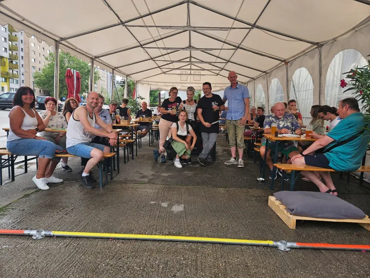 Gäste feiern im Festzelt der Braustube an langen Biertischen